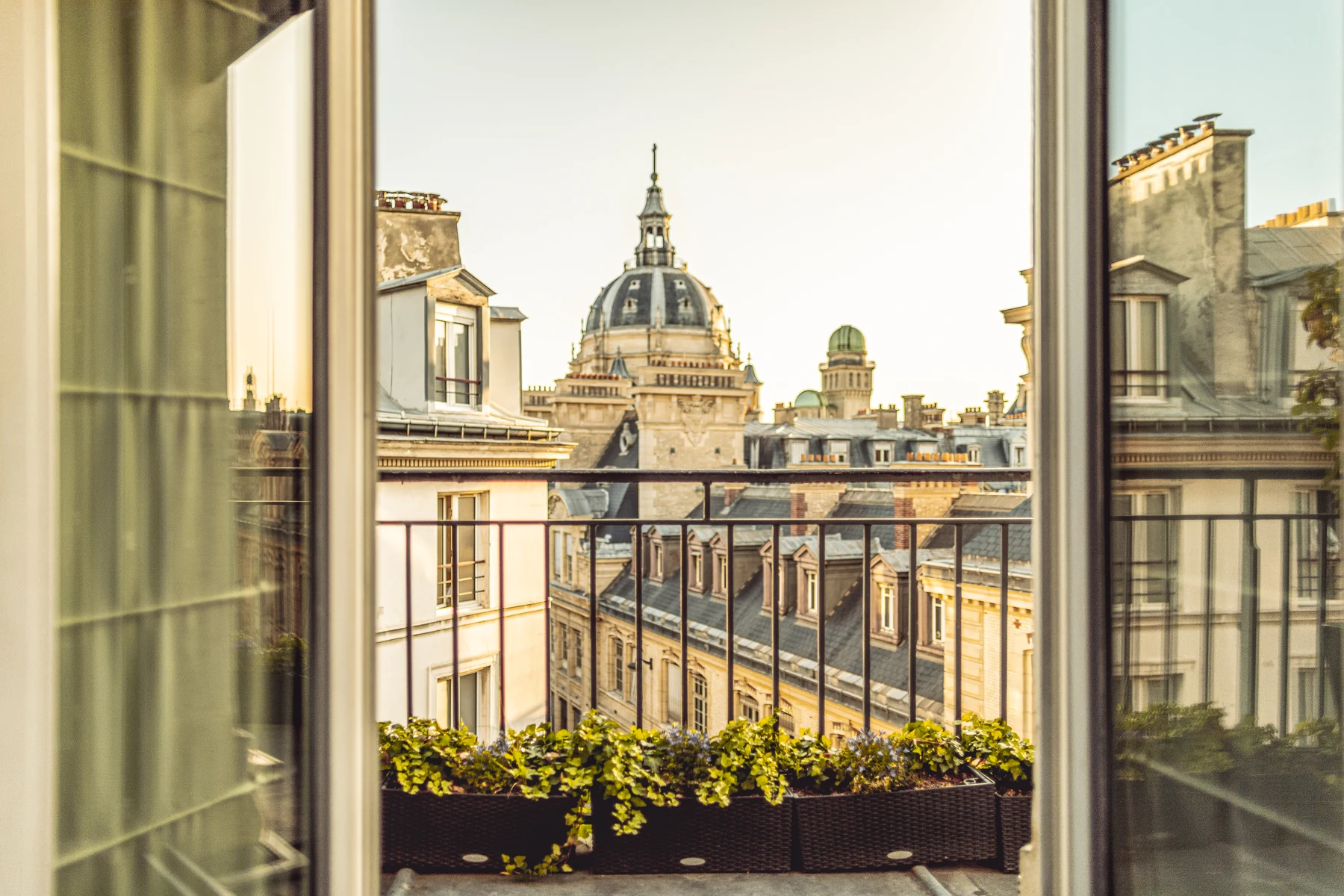 A Parisian window opening onto the rooftops and a dome