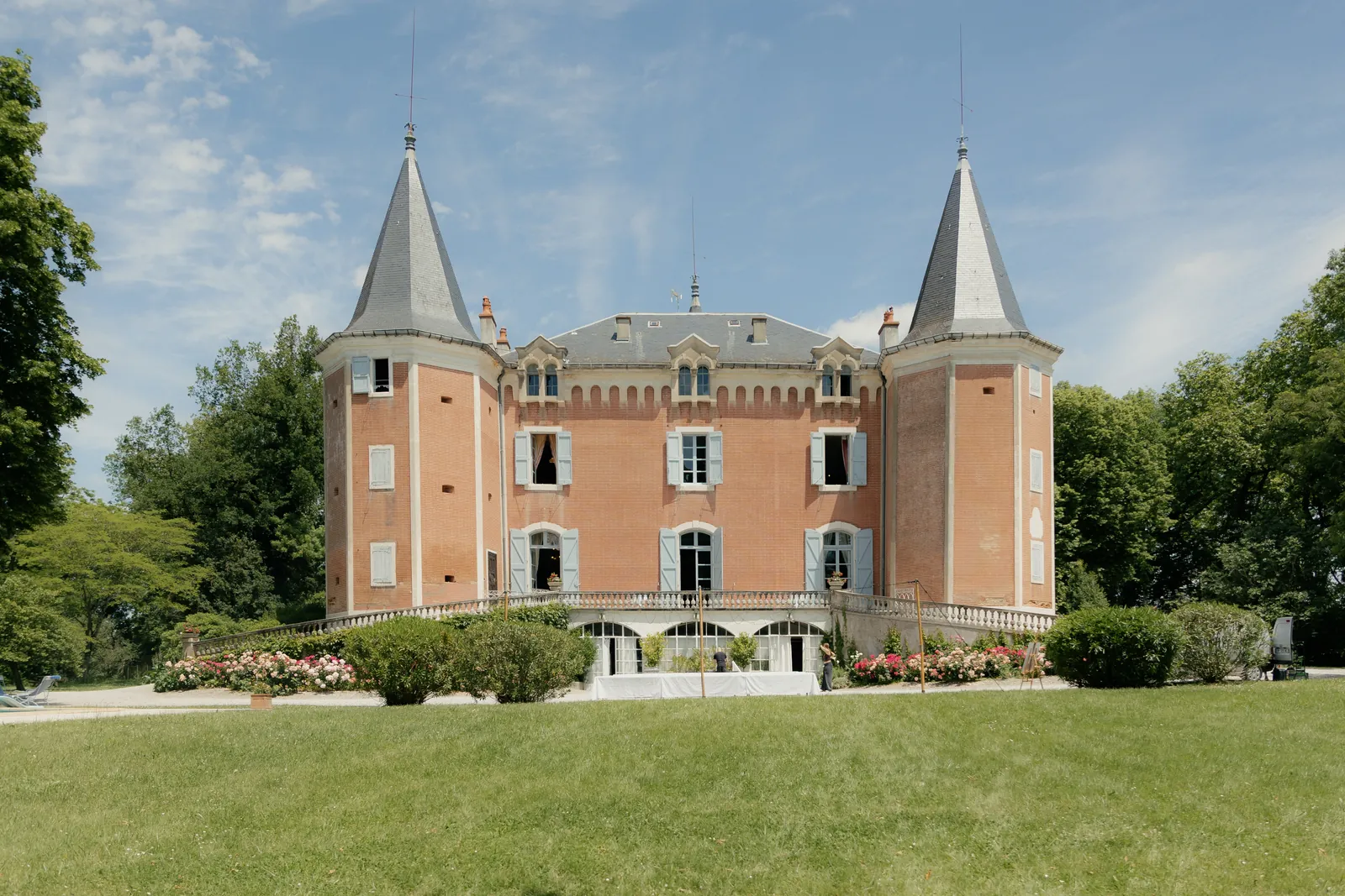 The façade of Château de Garrevaques and its lawn in summer