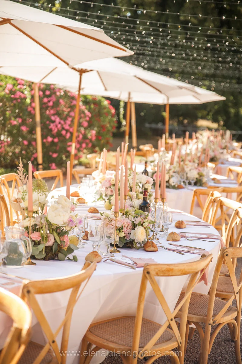 A long table under parasols and strings of light